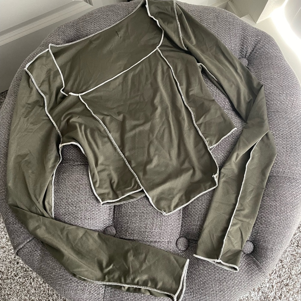 Not sure on brand, size small, dark green with white stitching.